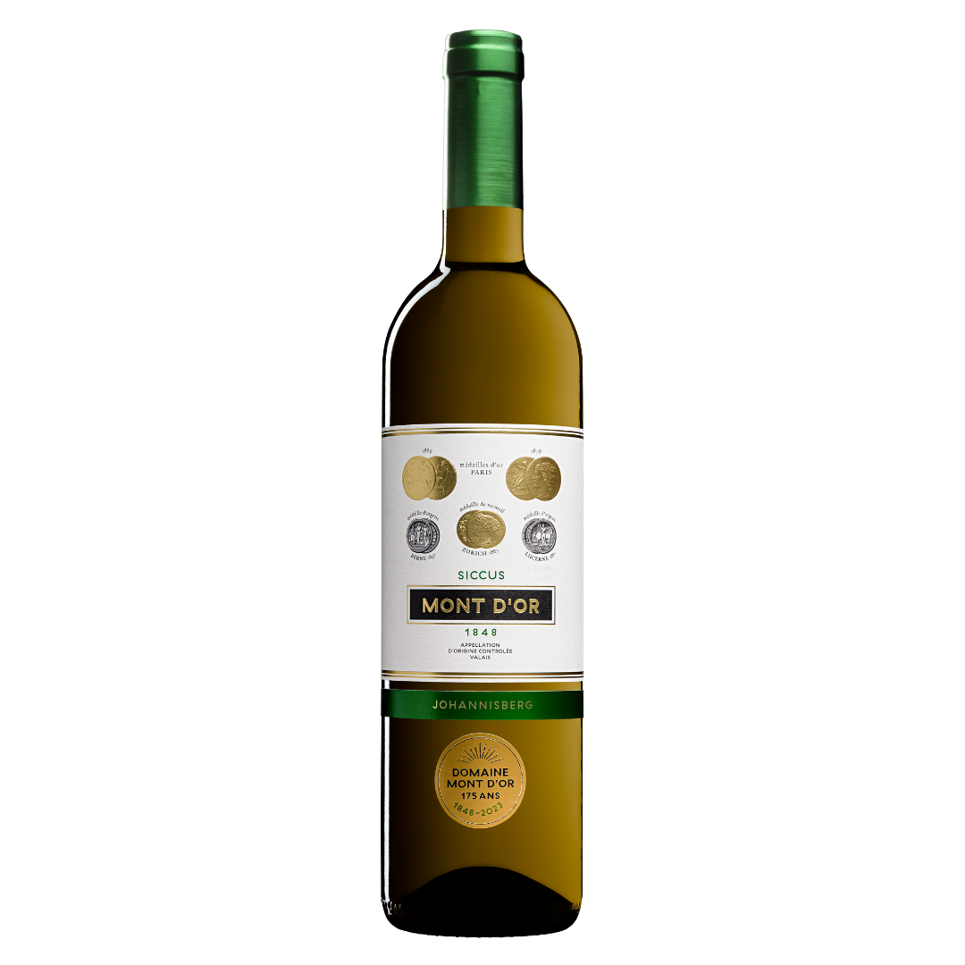 A bottle of Domaine du Mont d'Or Johannisberg “Siccus” 2023 white wine with a green cap. The label includes medals and information suggesting quality and origin from Domaine Johannisberg, AOC Valais.